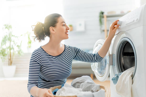 Woman Setting Time to Wash Clothes in Washing Machine