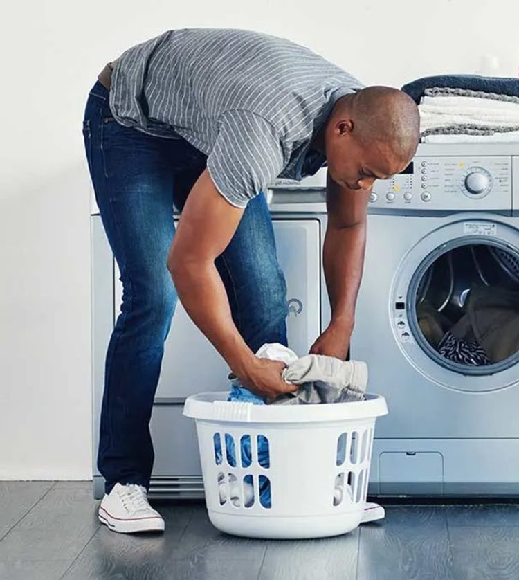 Two Persons Loading Washing Machine to Wash Filthy Clothes